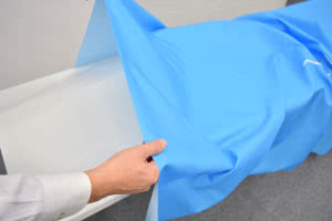 会場に用意されたテーブルにテーブルクロスを被せます